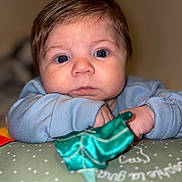 Isaïe participe au concours pour gagner de l'argent avec cette photo : baby, infant, portrait, face, blue_eyes, eyes, hair, cheeks, nose, mouth, hands, sleeve, pillow, blanket, toy, closeup, indoor, bokeh, soft_lighting, cute