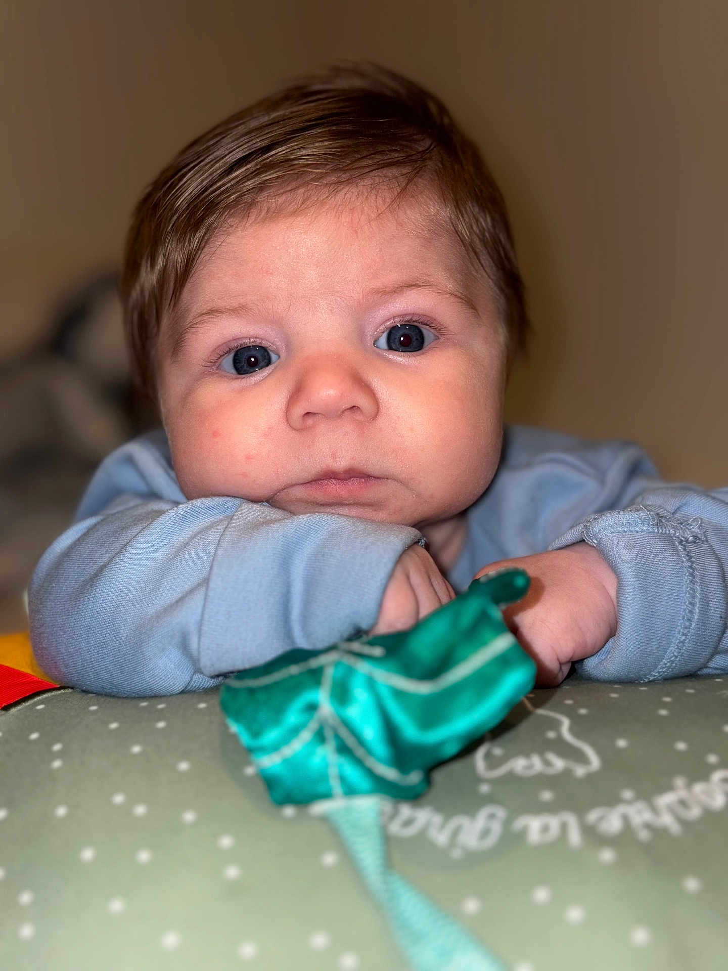 Isaïe participe au concours pour gagner de l'argent avec cette photo : baby, infant, portrait, face, blue_eyes, eyes, hair, cheeks, nose, mouth, hands, sleeve, pillow, blanket, toy, closeup, indoor, bokeh, soft_lighting, cute