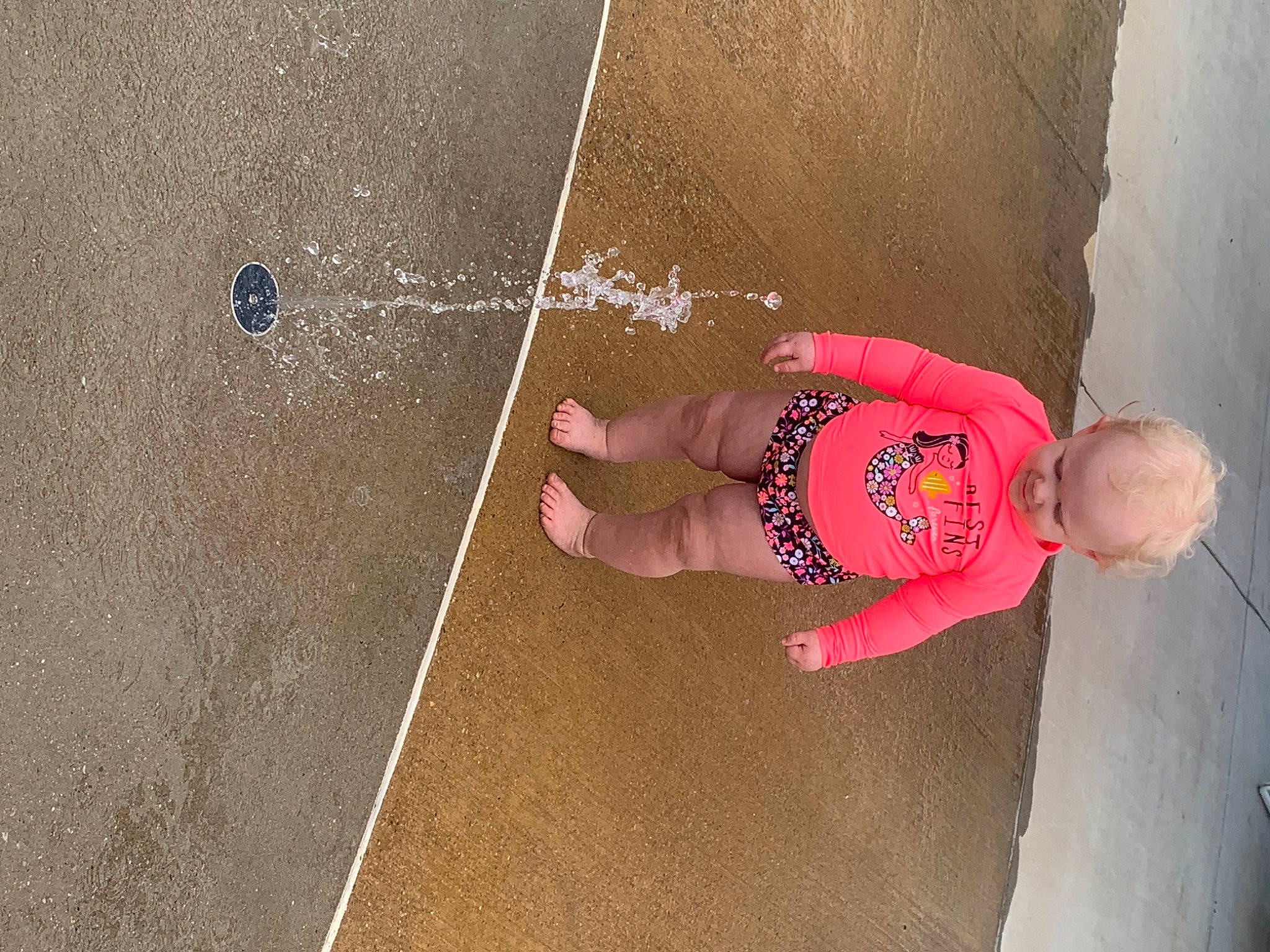 Bailee is registered to the contest to win money with this photo: baby, child, circle, concrete, floor, flooring, fun, happy, head, human_body, leg, leisure, person, play, recreation, sand, shadow, smile, toddler, water