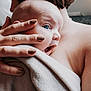 baby, adult, blue_eyes, blanket, hand, skin, close_up, hug, comfort, care, portrait, person, nail_polish, soft_texture, intimacy, love, warmth, indoor, family, tenderness