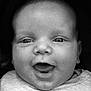 baby, close_up, black_and_white, face, infant, smiling, happy, expression, portrait, child, cute, young, apparel, sitting, head, skin, eyes, mouth, indoors, person