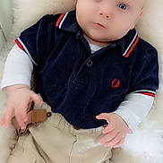 Hugo participe au concours pour gagner de l'argent avec cette photo : baby, beige_pants, blue_eyes, cargo_pants, child, clothing, cushion, cute, face, hand, indoor, infant, navy_shirt, person, polo_shirt, portrait, sitting, soft_texture, white_fur, young