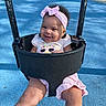 baby, child, swing, playground, smiling, happy, pink_bow, headband, outdoor, park, infant, portrait, sitting, play_equipment, blue_ground, sunlight, summer, clothing, face, joyful