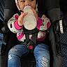Raniah is registered to the contest to win money with this photo: baby, child, infant, bottle, feeding, car_seat, harness, hood, outfit, pink, white, jeans, clothing, sitting, portrait, face, indoors, vehicle, passenger, cozy