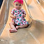 toddler, child, slide, playground, pink_bow, dress, strawberry_pattern, outdoor, sunlight, barefoot, play, fun, smile, cute, park, equipment, happy, young_child, summer, recreation