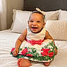 Aliyah Olivia is registered to the contest to win money with this photo: baby, child, smiling, laughing, portrait, indoor, bedroom, bed, dress, floral_dress, bow, headband, pink, white, sitting, barefoot, pillow, headboard, happy, photography