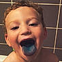 Léo a rejoint le concours — aidez-le/la à gagner de superbes lots ! child, boy, blue_tongue, curly_hair, bathroom, tiles, water_droplets, playful, close_up, smiling, tongue_out, skin, face, happy, cute, indoors, portrait, wet, mischievous, fun