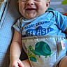 Dean joined the competition — help win amazing prizes! baby, child, infant, smiling, happy, portrait, seated, activity_seat, blue_shirt, dinosaur, colorful, indoors, chair, playroom, close_up, face, eyes, hands, legs, casual_clothing