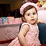 baby, celebration, chair, child, closeup, curly_hair, cute, decorations, expression, furniture, happy, headband, indoor, party, pink_dress, plush_toy, portrait, seated, soft_lighting, toddler