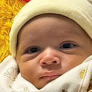 Andre is registered to the contest to win money with this photo: baby, infant, face, hat, blanket, clothing, cute, close_up, expression, newborn, soft, warm, cozy, portrait, wrapped, eyes, skin, headwear, child, indoors