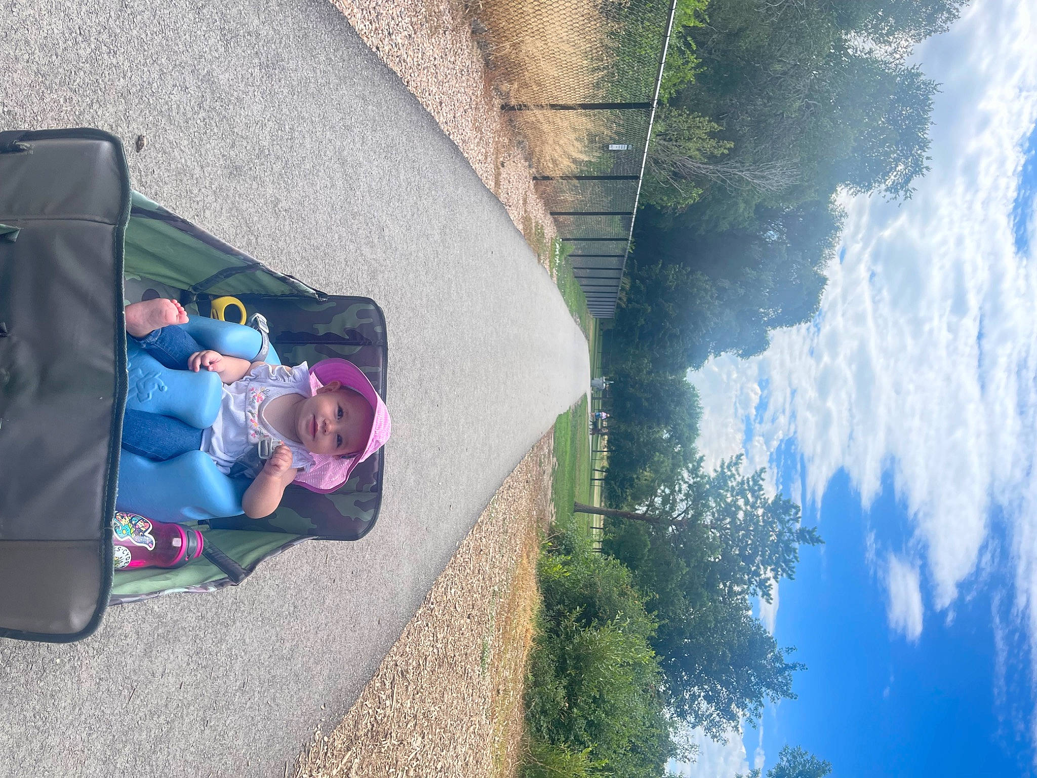 Shea is registered to the contest to win money with this photo: asphalt, azure, cloud, grass, headwear, joy, landscape, leaf, leisure, morning, person, plant, reflection, road_surface, rock, shadow, sidewalk, sky, tints_and_shades, toddler