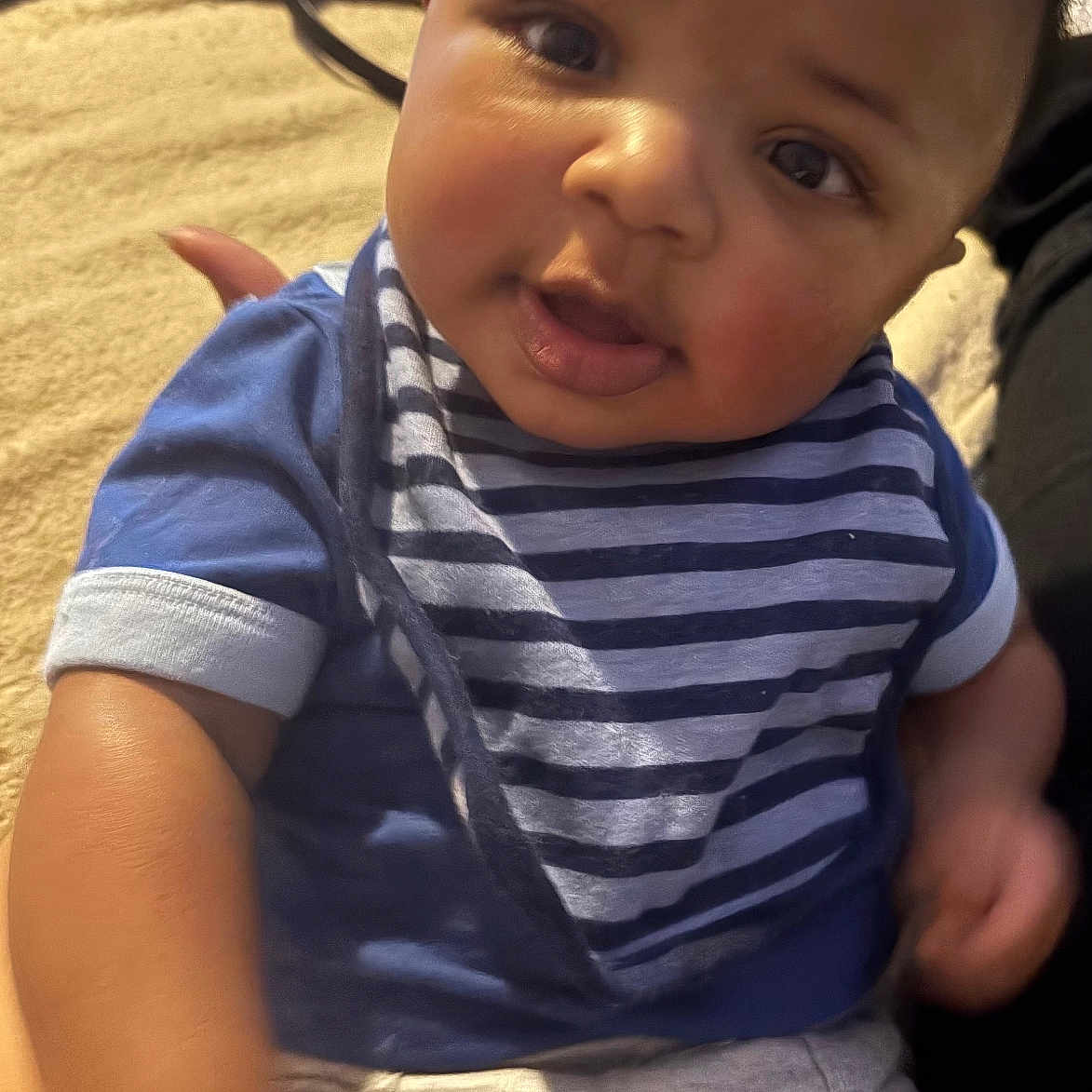 Ravi is registered to the contest to win money with this photo: baby, babylaughing, bodypart, clothing, couch, face, finger, furniture, hand, happy, head, laughing, pants, person, photography, portrait, shirt, sitting, smile, t_shirt