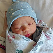 Alice joined the competition — help win amazing prizes! newborn, baby, sleeping, blanket, hat, blue_hat, footprint_pattern, infant, closeup, face, peaceful, swaddled, hand, skin, cute, resting, indoors, soft_light, portrait, cozy