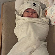 Elio participe au concours pour gagner de l'argent avec cette photo : adorable, baby, bear, child, clothing, comfortable, cozy, cushion, cute, face, hood, indoors, infant, lying, portrait, smile, soft, towel, white, wrapped