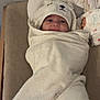 adorable, baby, bear, child, clothing, comfortable, cozy, cushion, cute, face, hood, indoors, infant, lying, portrait, smile, soft, towel, white, wrapped