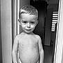 Mattoe is registered to the contest to win money with this photo: child, boy, portrait, black_and_white, indoors, doorway, smile, shirtless, young_child, short_hair, bracelet, expression, face, looking_at_camera, standing, monochrome, home, light, shadow, wall