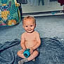 baby, child, smile, sitting, blanket, sippy_cup, indoor, carpet, toy, laundry, window, curtains, sock, playtime, happy, home, radiator, clothing, floor, person