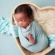 Isaac participe au concours pour gagner de l'argent avec cette photo : newborn, baby, sleeping, wrapped, blanket, heart_shaped_bowl, wooden_bowl, soft_texture, mint_green, cream_fur, peaceful, infant, cute, cozy, portrait, foot, hand, head, baby_clothing, indoor