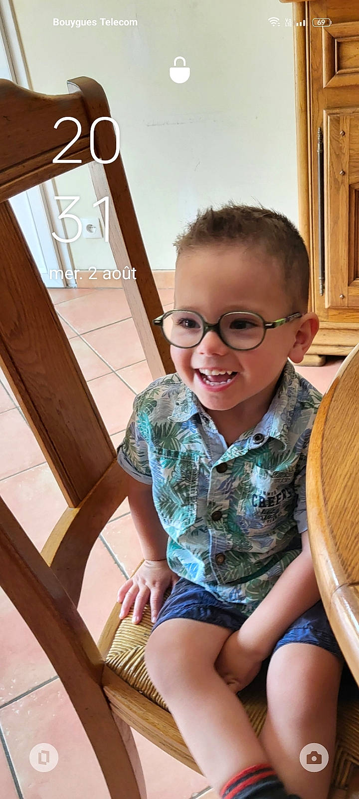 Nolan a rejoint le concours — aidez-le/la à gagner de superbes lots ! chair, child, eyewear, face, flooring, fun, glasses, happy, head, human_leg, joy, lap, leg, leisure, person, shorts, sitting, smile, thigh, toddler