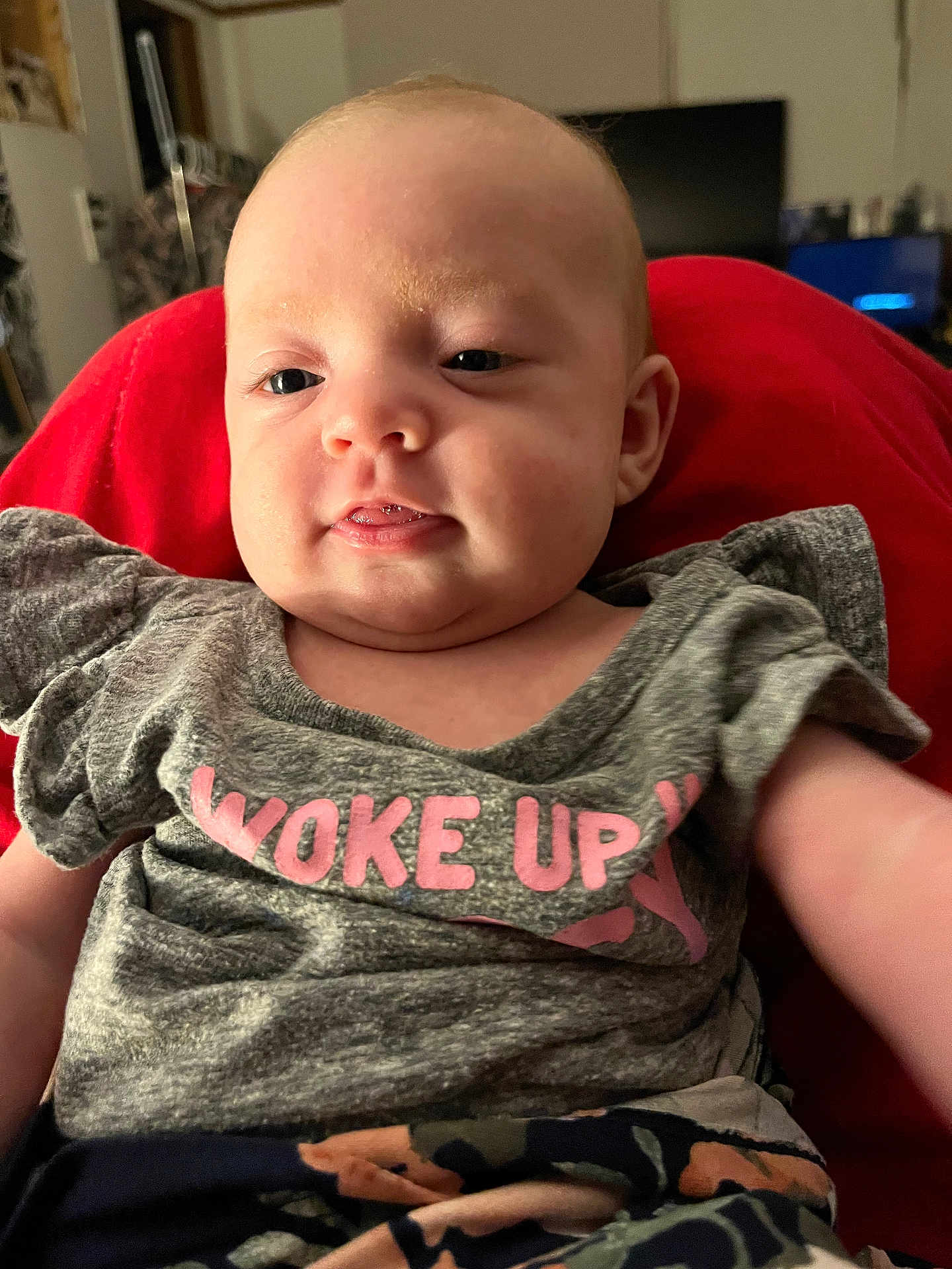Brooklynn joined the competition — help win amazing prizes! baby, child, face, smile, clothing, shirt, red_background, indoor, person, cute, portrait, skin, head, young, infant, expression, seated, relaxed, casual, home