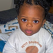 Kaecy participe au concours pour gagner de l'argent avec cette photo : child, toddler, baby, pacifier, pajamas, onesie, curly_hair, big_eyes, portrait, closeup, indoor, bed, blanket, hand, face, expression, mouth, bedding, water_bottles, room