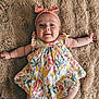 baby, infant, smiling, headband, floral_dress, pink, cute, lying_down, rug, soft_texture, happy, child, indoors, skin, arms_outstretched, legs, portrait, person, fashion, baby_girl