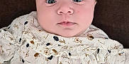 Elma a rejoint le concours — aidez-le/la à gagner de superbes lots ! baby, infant, face, person, clothing, dress, floral_pattern, hand, nail_art, manicure, heart_emoji, lying_down, cute, child, skin, eyes, fingernails, brown_background, adorable, closeup