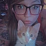 woman, glasses, tattoo, cat, kitten, orange_and_white, collar, bell, face, closeup, selfie, indoor, heart_shape, pet, cute, animal, young_adult, expression, portrait, curious