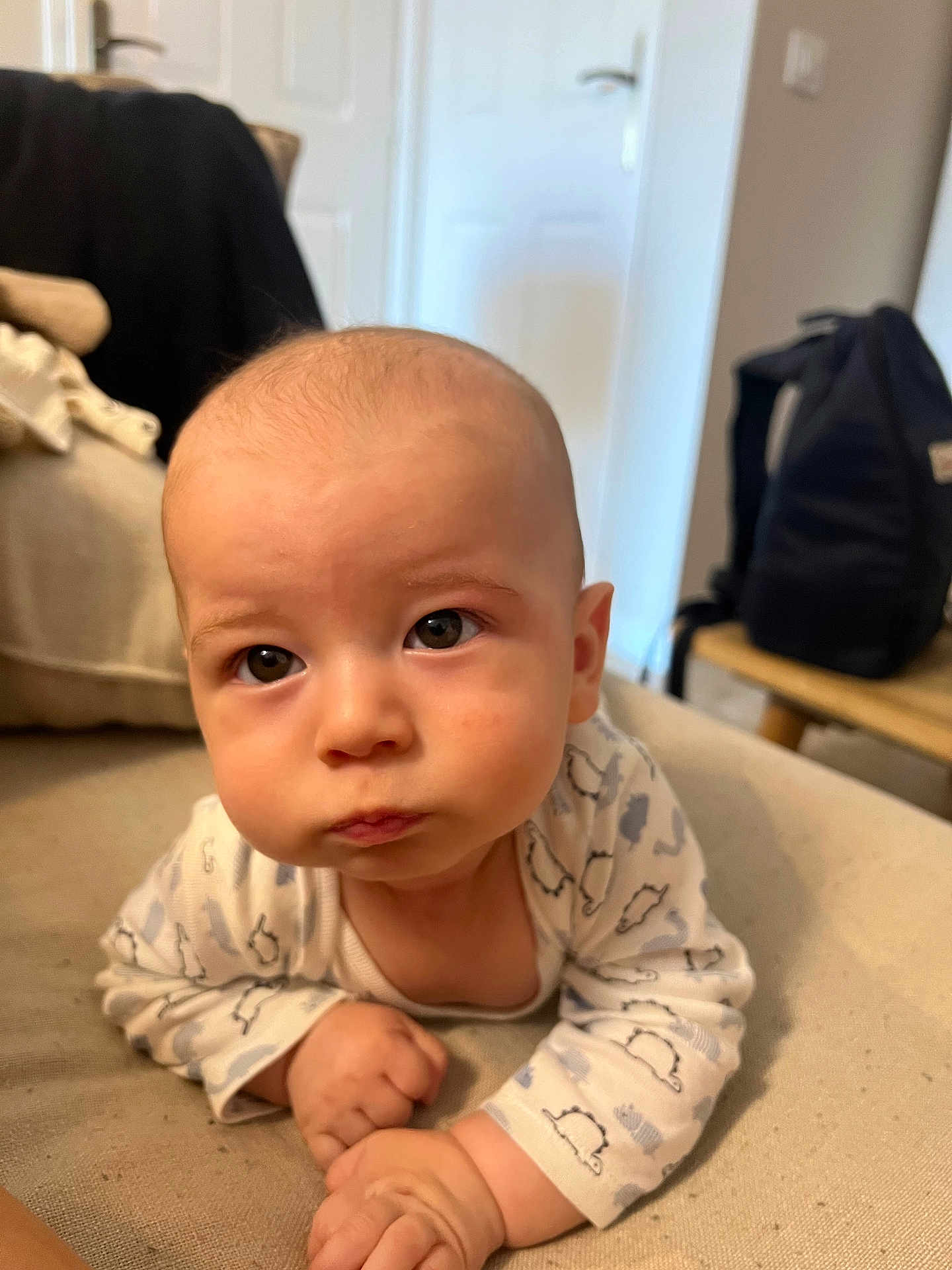 Mayronn participe au concours pour gagner de l'argent avec cette photo : baby, infant, child, portrait, face, eyes, pout, hands, onesie, sofa, couch, blanket, home_interior, backpack, door, closeup, cute, soft_lighting, skin, expression
