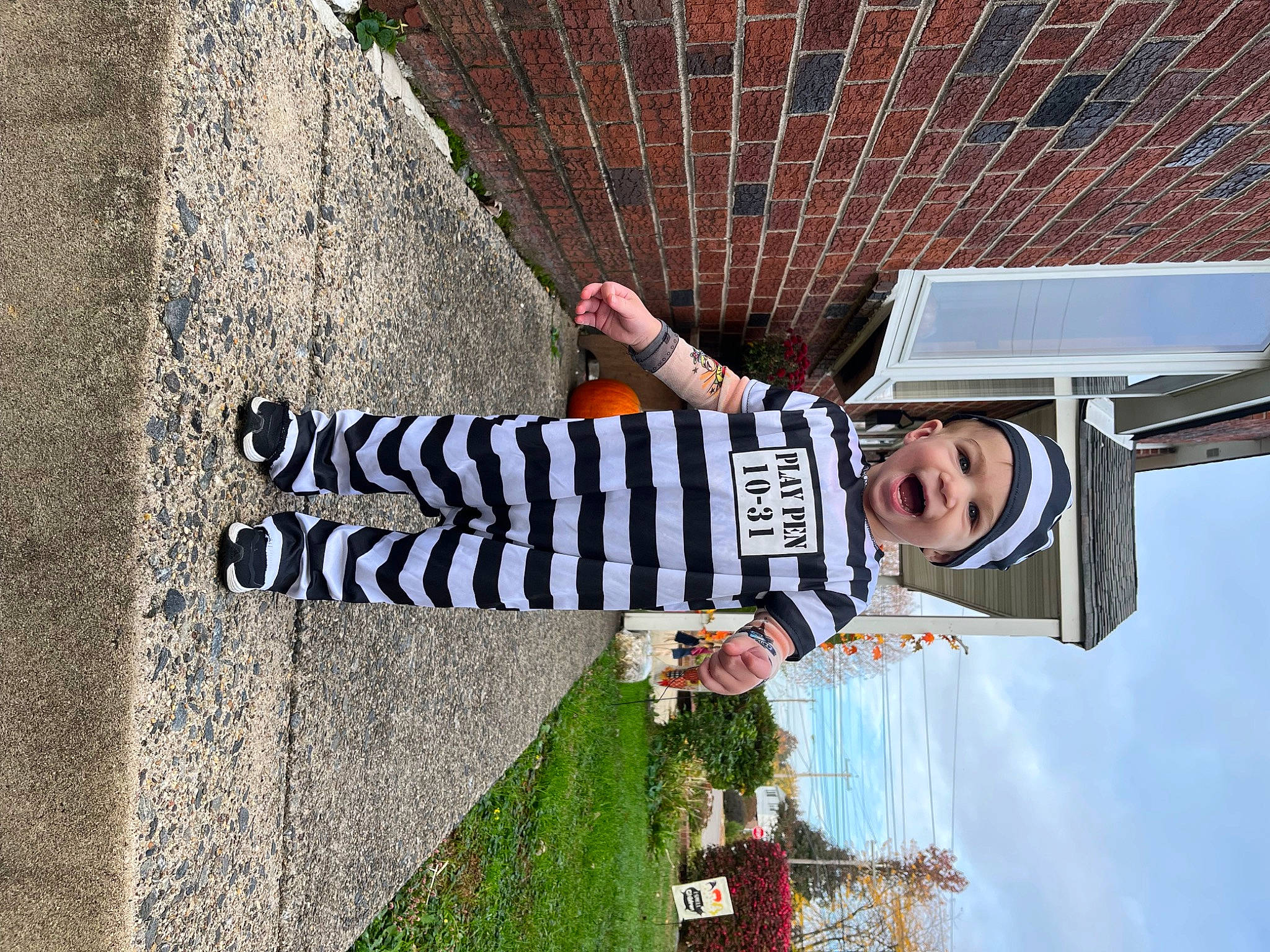 Chase is registered to the contest to win money with this photo: brick, brickwork, cloud, concrete, facade, fun, headwear, leisure, line, pattern, person, road_surface, shadow, sky, smile, travel, tree, walking_shoe, wall