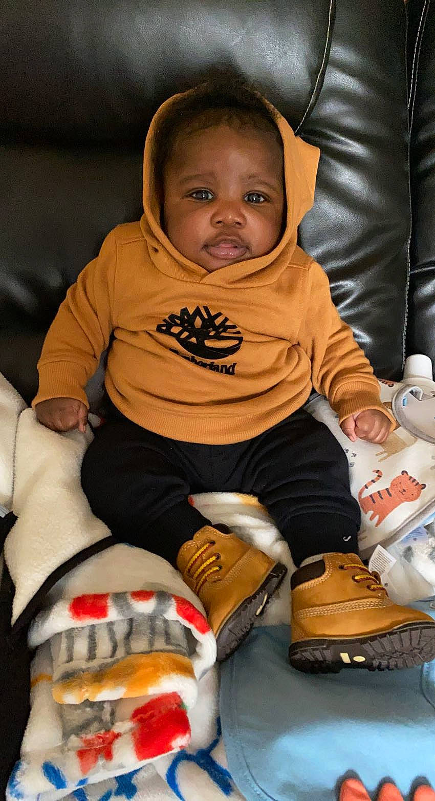 Hassan is registered to the contest to win money with this photo: arm, baby, baby_toddler_clothing, cheek, comfort, cool, eye, face, finger, hand, human_body, joint, knee, mammal, mouth, person, skin, sleeve, sock, toddler