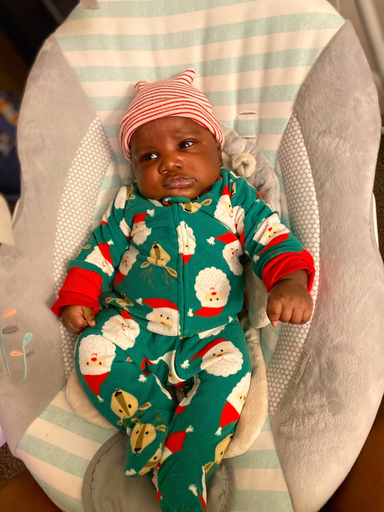 Hassan is registered to the contest to win money with this photo: arm, baby, baby_products, baby_safety, baby_sleeping, baby_toddler_clothing, cap, carmine, chair, cheek, child, circle, comfort, headwear, linens, outerwear, pattern, person, product, sitting