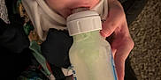 Darren is registered to the contest to win money with this photo: baby, bottle, care, carpet, child, closeup, clothing, cute, face, feeding, feeding_time, hand, indoor, infant, milk, newborn, patterned_clothing, person, sleepwear, soft_lighting