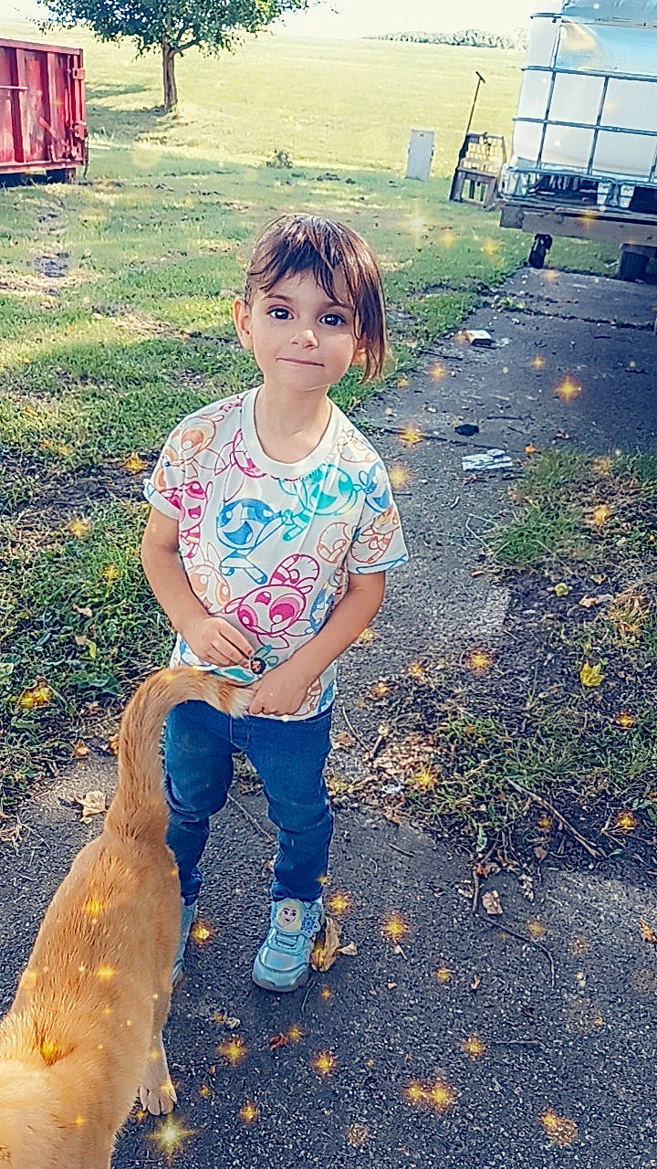 Adelynn is registered to the contest to win money with this photo: asphalt, beauty, child, cool, denim, fun, grass, hairstyle, happy, head, human_leg, leisure, light, people_in_nature, person, sitting, soil, sunlight, t_shirt, tints_and_shades