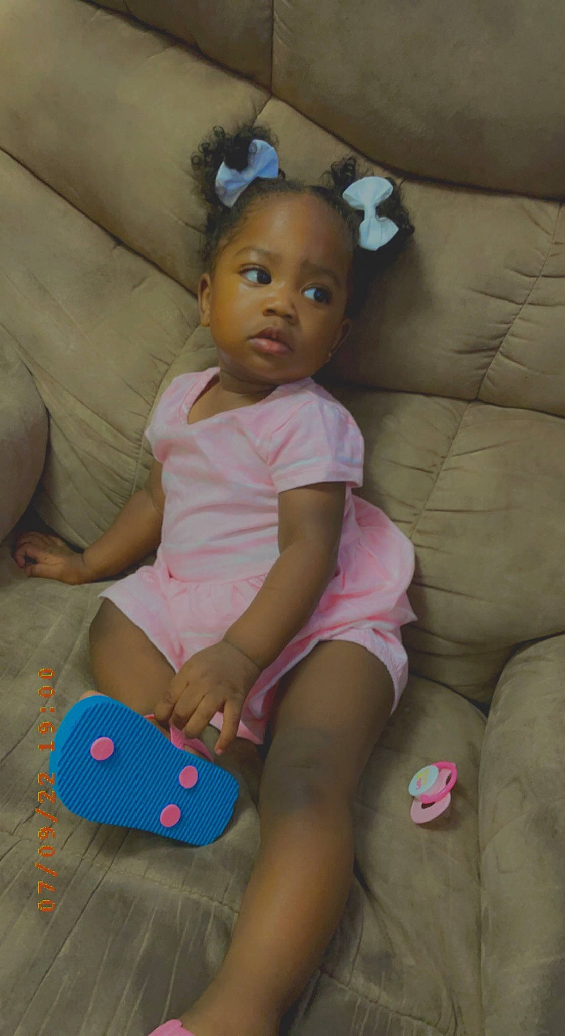 Torri is registered to the contest to win money with this photo: abdomen, baby_toddler_clothing, child, comfort, couch, doll, fun, hand, head, human_body, human_leg, knee, person, pink, sitting, skin, thigh, toddler, toy, trunk