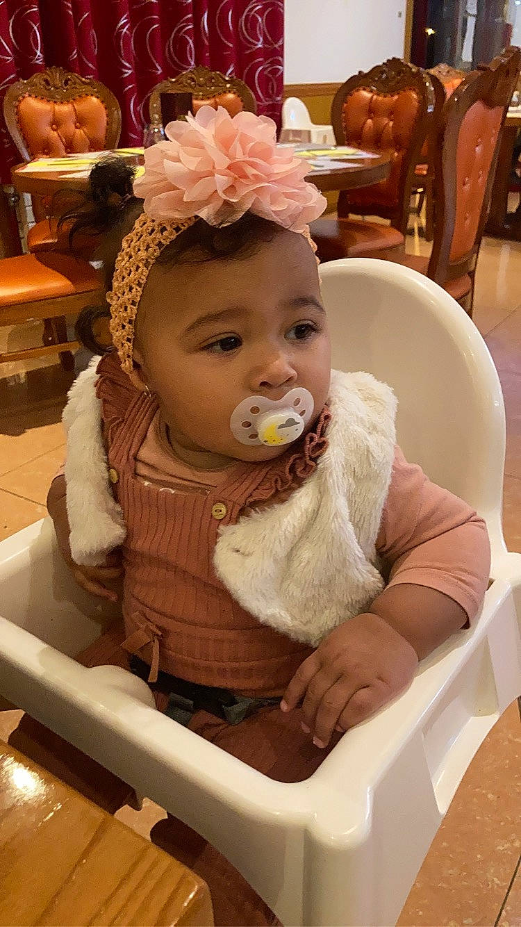 Talhïa participe au concours pour gagner de l'argent avec cette photo : baby, baby_products, baby_toddler_clothing, chair, cheek, child, chin, comfort, event, fashion_accessory, fun, happy, head, headpiece, iris, person, plant, room, sitting, skin