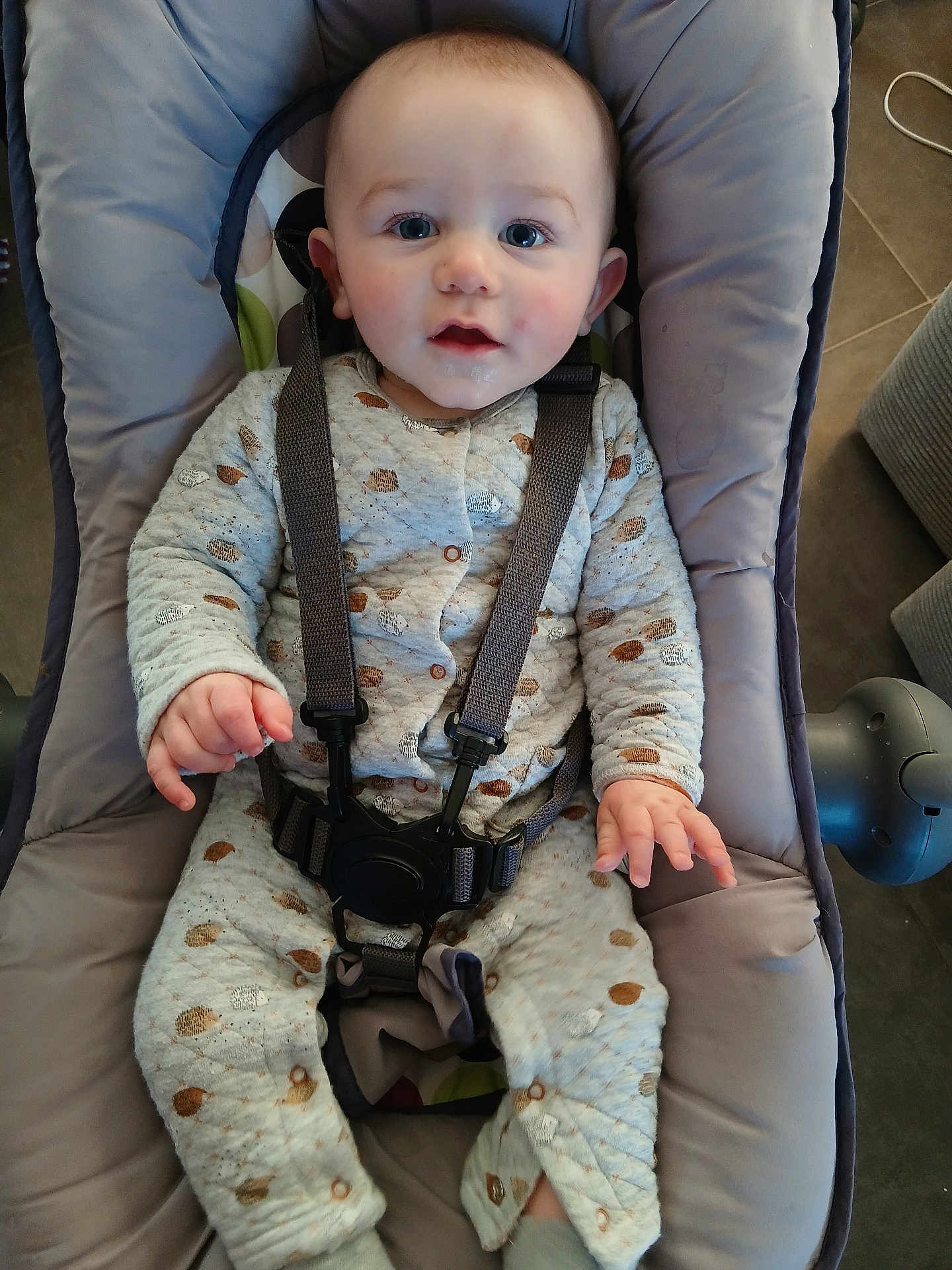 Kaëzyo participe au concours pour gagner de l'argent avec cette photo : baby, child, onesie, baby_seat, harness, blue_eyes, drool, cozy, patterned_clothing, infant, cute, indoor, soft_fabric, seat, child_safety, person, face, hand, footwear, floor