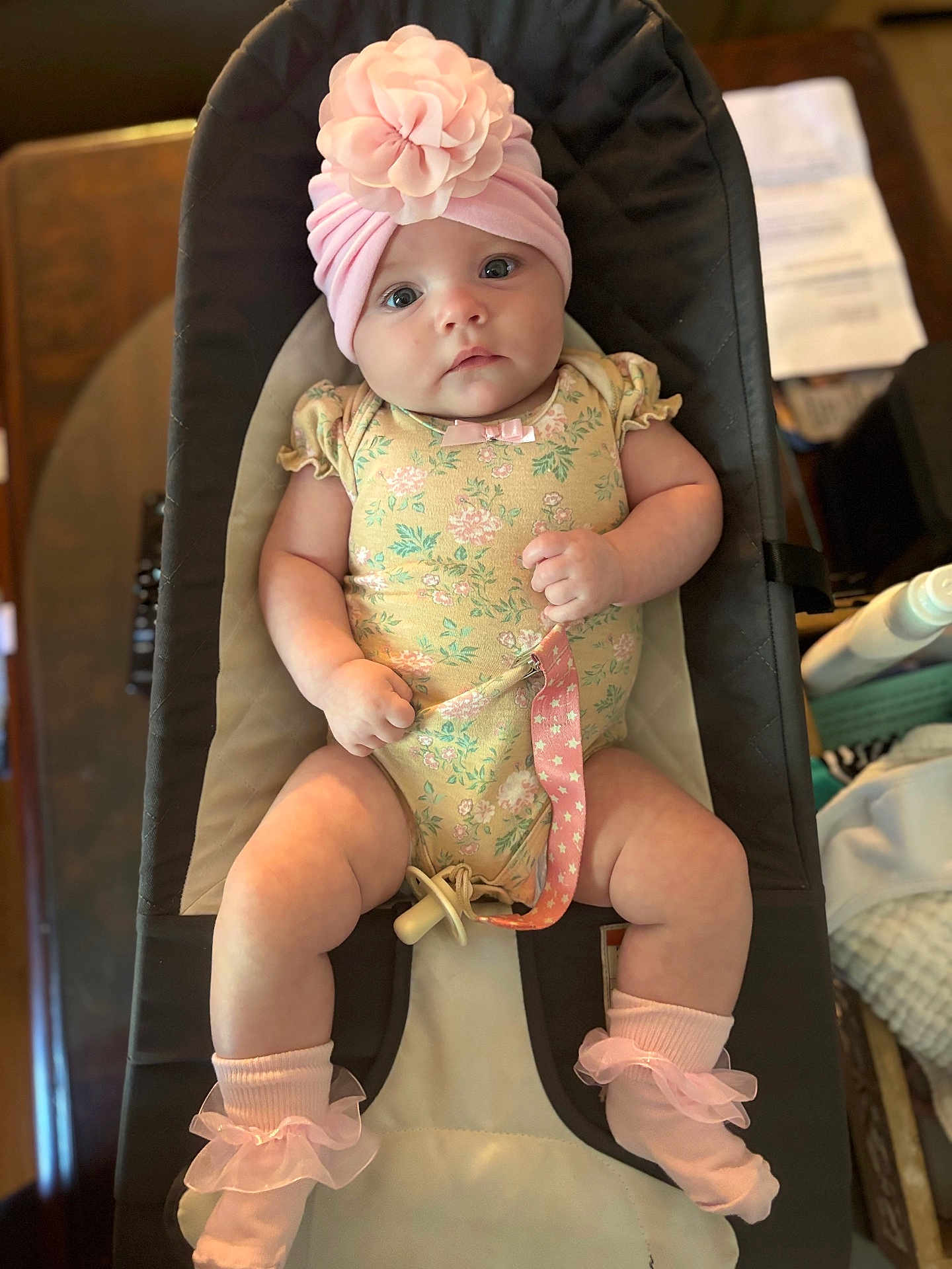 Estaleen joined the competition — help win amazing prizes! baby, infant, child, pink_hat, floral_onesie, pacifier, baby_seat, socks, cute, indoor, portrait, chubby_arms, chubby_legs, clothing, headwear, looking_at_camera, soft_lighting, infant_accessory, baby_fashion, human