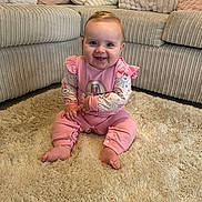 Lena is registered to the contest to win money with this photo: baby, carpet, child, cozy, cushion, cute, face, floor, furniture, happy, home, indoor, infant, person, pink_clothing, plush, sitting, smiling, sofa, toddler