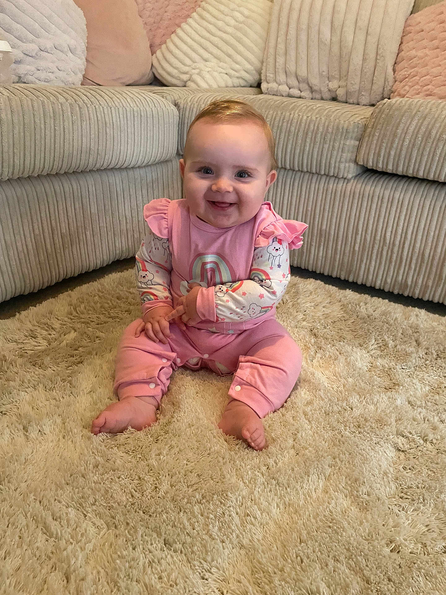 Lena is registered to the contest to win money with this photo: baby, carpet, child, cozy, cushion, cute, face, floor, furniture, happy, home, indoor, infant, person, pink_clothing, plush, sitting, smiling, sofa, toddler