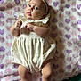 Allison is registered to the contest to win money with this photo: baby, infant, blanket, hearts, headband, flower, romper, socks, cute, soft_texture, lying_down, child, portrait, indoor, clothing, expression, skin, hands, legs, face