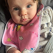 Ambre participe au concours pour gagner de l'argent avec cette photo : baby, child, infant, car_seat, seatbelt, pink_bib, headband, flower, hand, curly_hair, clothing, cute, portrait, indoor, closeup, face, eyes, expression, sitting, young