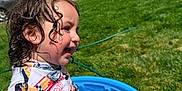 Lorenzo joined the competition — help win amazing prizes! blue_pool, car, child, colorful_clothing, curly_hair, grass, happy, outdoor, person, playing, pool, racing_shirt, residential_area, sidewalk, smiling, summer, sunny, toddler, water, wet_hair