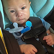 Adan joined the competition — help win amazing prizes! baby, car_seat, pacifier, infant, child, blue_clothing, black_harness, straps, safety, seat_belt, closeup, cute, serious_expression, hands, indoor, portrait, young_child, seat, child_safety, infant_seat