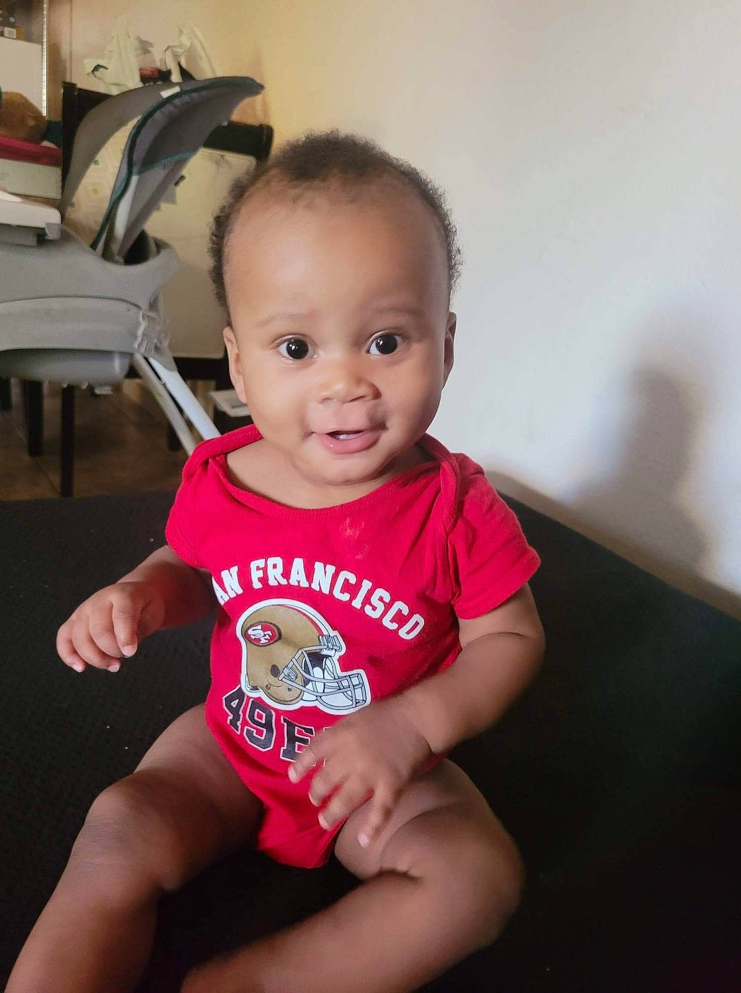 Jamir Jones is registered to the contest to win money with this photo: baby, baby_toddler_clothing, cheek, child, elbow, finger, flooring, fun, happy, human_leg, iris, joint, knee, person, shoulder, sitting, skin, sleeve, smile, t_shirt