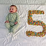 Jagger is registered to the contest to win money with this photo: age_marker, baby, bed, breakfast, celebration, cereal, colorful, cute, footed_pajamas, hands, infant, lying_down, marshmallows, milestone, number_five, onesie, portrait, smiling, snack, white_sheet