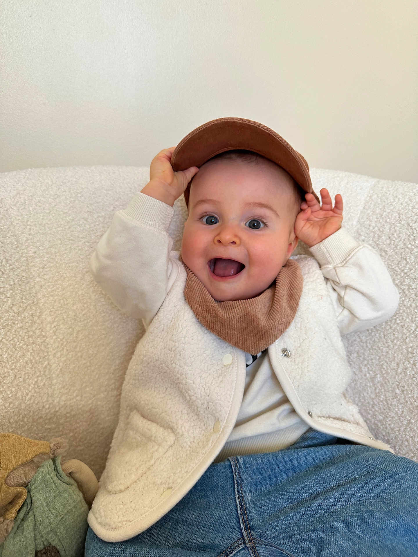 Ayden a rejoint le concours — aidez-le/la à gagner de superbes lots ! baby, child, smiling, happy, cap, hat, jacket, fleece, clothing, sitting, chair, indoor, portrait, cute, young, person, face, hands, denim, scarf