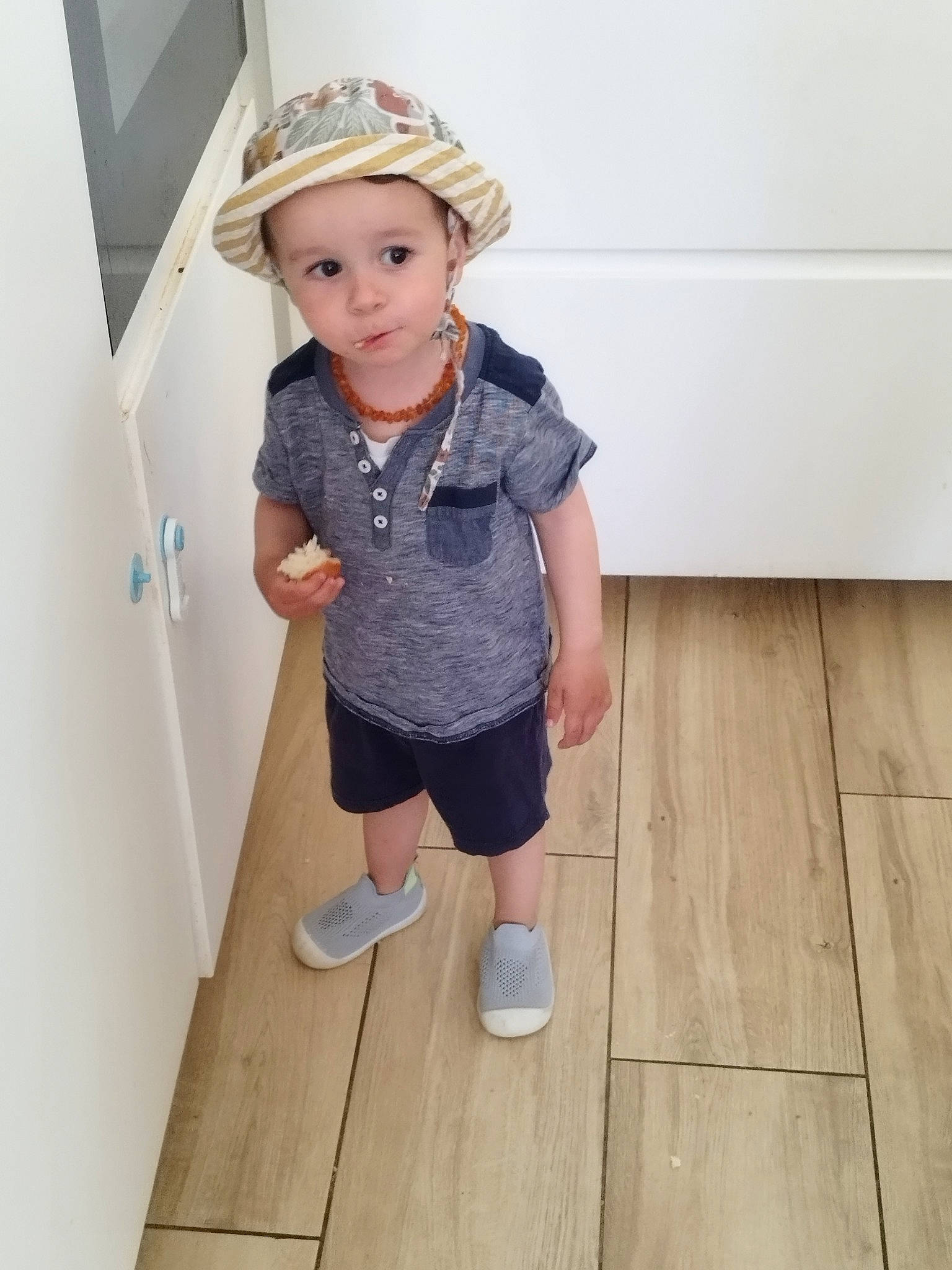 Evan participe au concours pour gagner de l'argent avec cette photo : baby_toddler_clothing, blond, denim, electric_blue, floor, flooring, hardwood, hat, headwear, human_body, knee, leg, pattern, person, shorts, sleeve, standing, t_shirt, toddler, waist