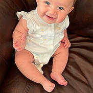 Brenlee is registered to the contest to win money with this photo: baby, blue_eyes, child, chubby_arms, chubby_legs, cute, feet, furniture, hands, happy, head, indoor, infant, leather_couch, portrait, sitting, skin, smiling, white_outfit, young