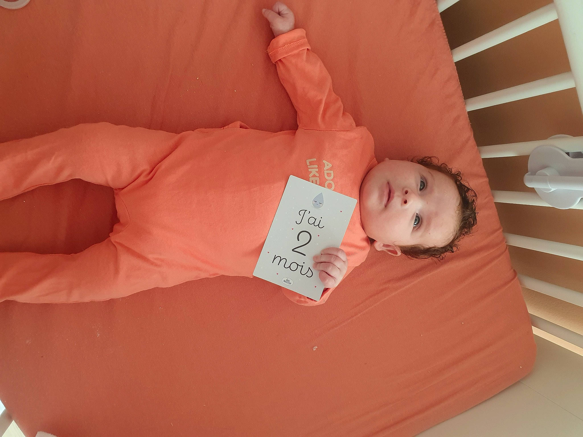 Giulia a rejoint le concours — aidez-le/la à gagner de superbes lots ! baby, baby_products, baby_toddler_clothing, bed, bedtime, child, comfort, elbow, finger, flooring, gesture, hardwood, human_leg, infant_bed, linens, person, pink, skin, thumb, toddler